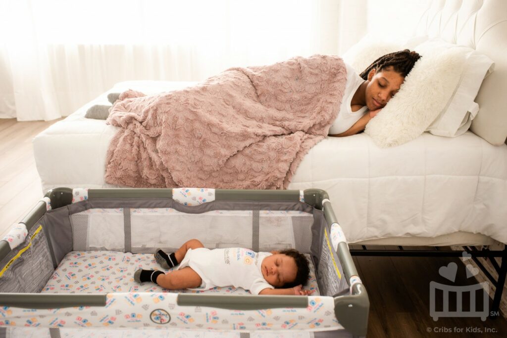 Baby sleeping in crib in mother's room